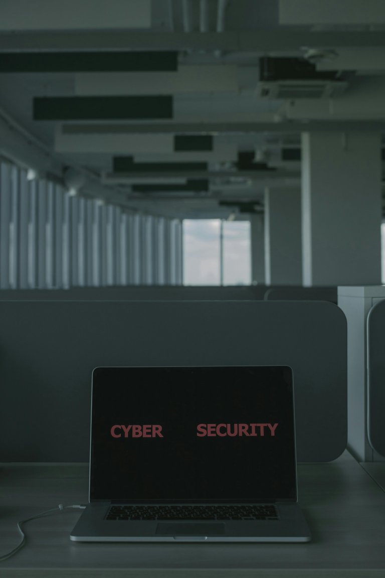 Computador portátil con la palabra cyber security en la pantalla sobre un escritorio de oficina