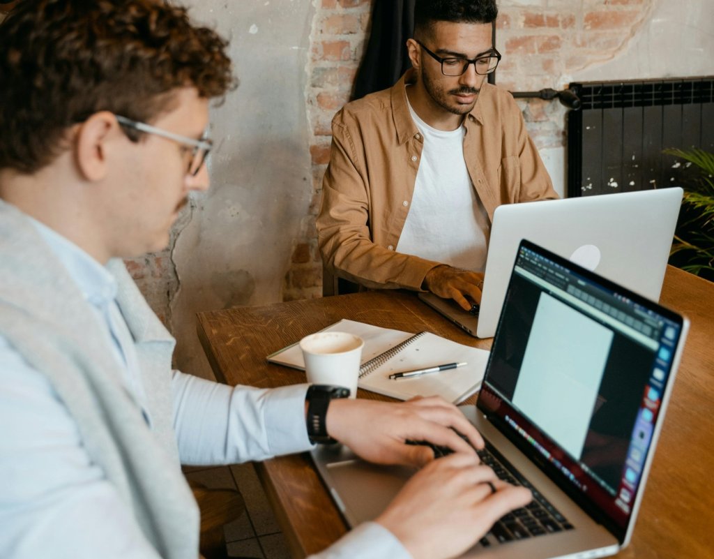 Dos profesionales trabajando con portátiles en una oficina en Bogotá