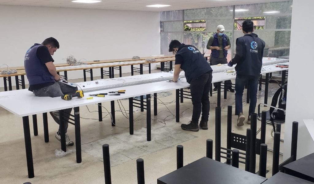 Técnicos de Col-Tek instalando cableado de red en una oficina